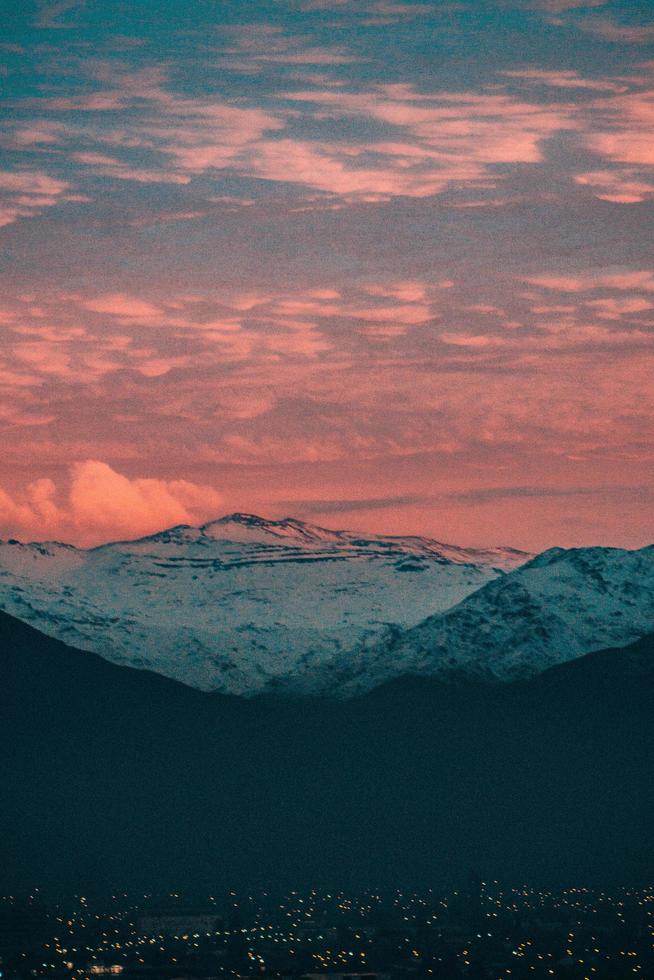 schneebedeckter Berg unter Sonnenuntergangswolken foto