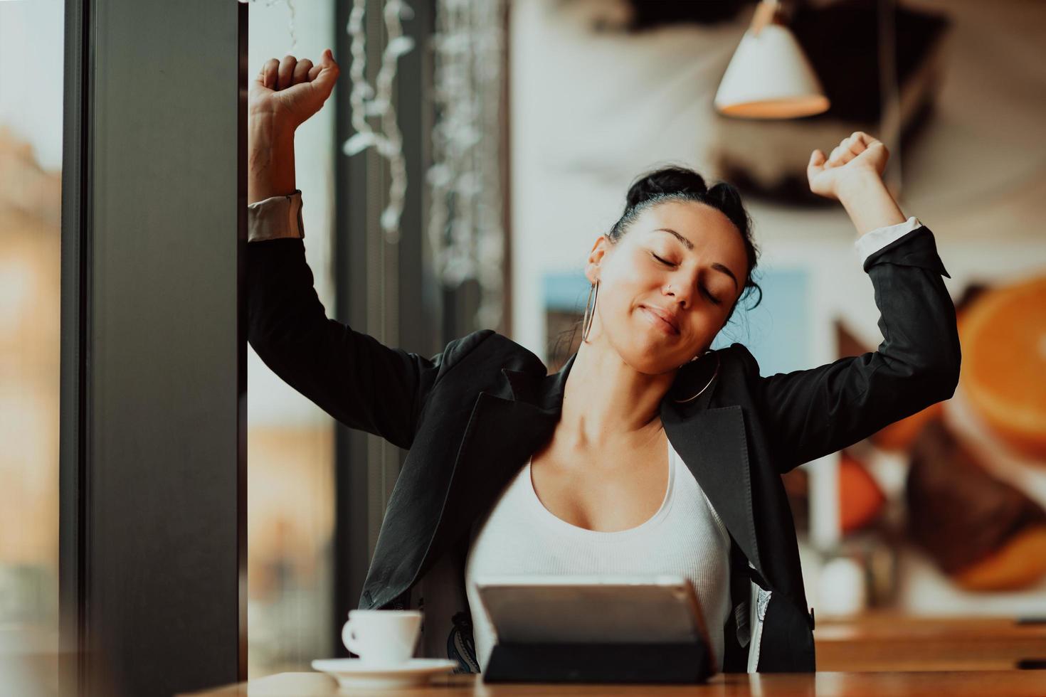 eine Latino-Frau, die in einer Pause von der Arbeit in einem Café sitzt foto