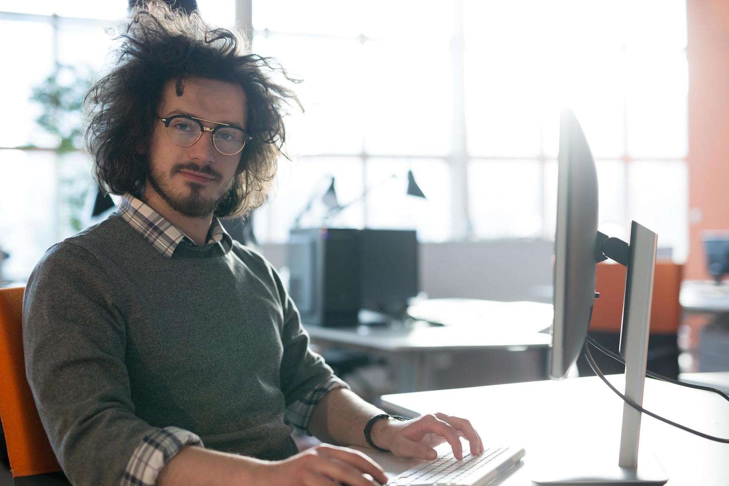 Geschäftsmann, der mit einem Computer im Startup-Büro arbeitet foto