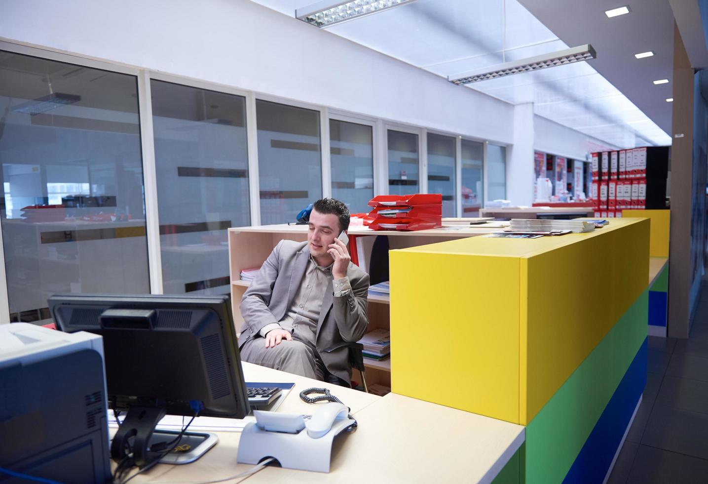 Geschäftsmann, der per Telefon im Büro spricht foto