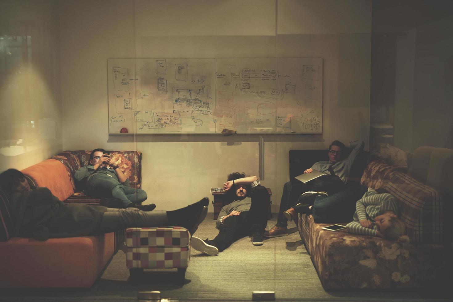 softwareentwickler, die auf dem sofa im kreativen startbüro schlafen foto