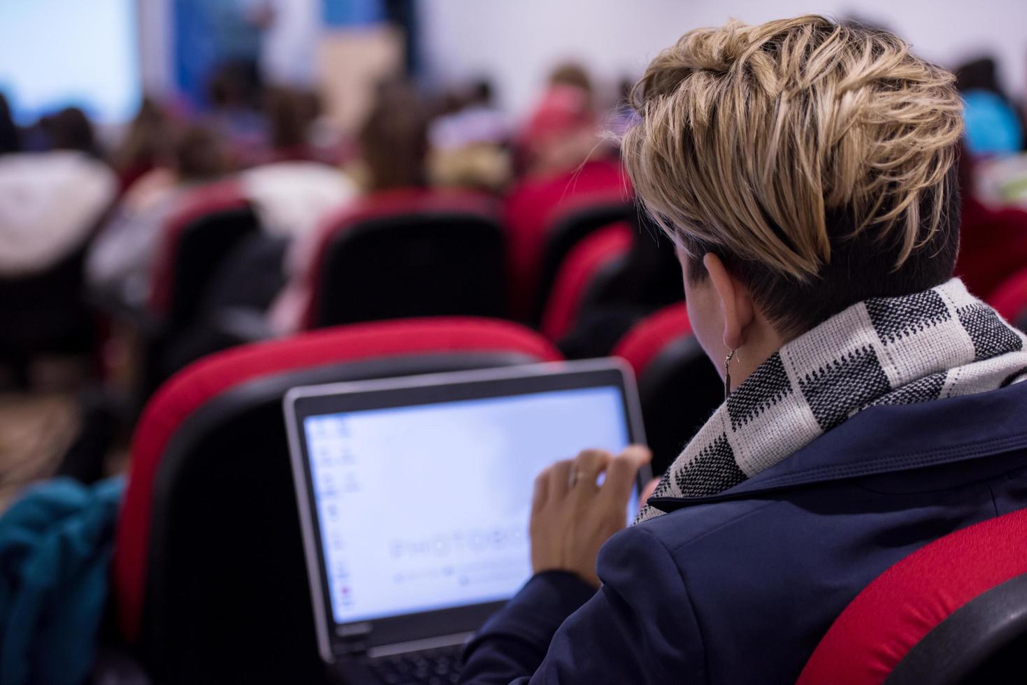 Geschäftsfrau mit Laptop-Computer während des Seminars foto