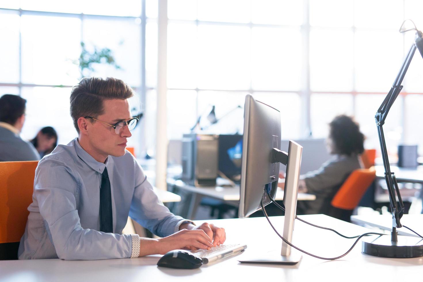 Geschäftsmann, der mit einem Computer im Startup-Büro arbeitet foto