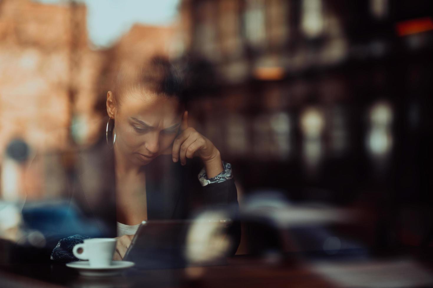 eine Latino-Frau, die in einer Pause von der Arbeit in einem Café sitzt foto