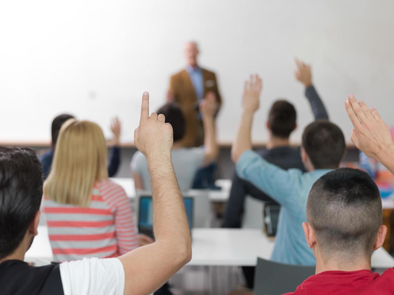 studentengruppe hebt die hände in der klasse foto