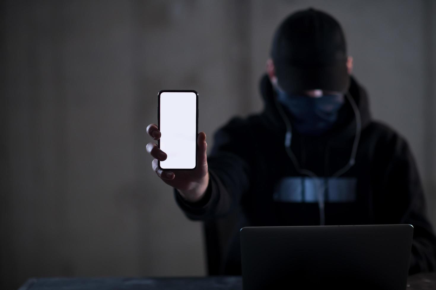 krimineller hacker, der einen laptop verwendet, während er im dunklen büro arbeitet foto
