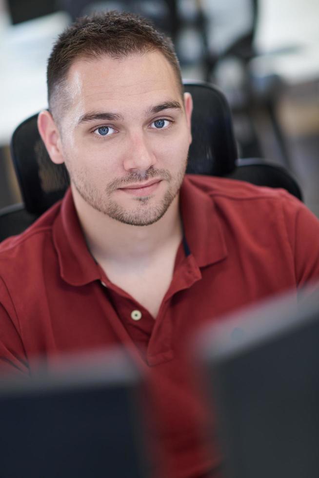 Gelegenheitsgeschäftsmann, der an einem Desktop-Computer arbeitet foto