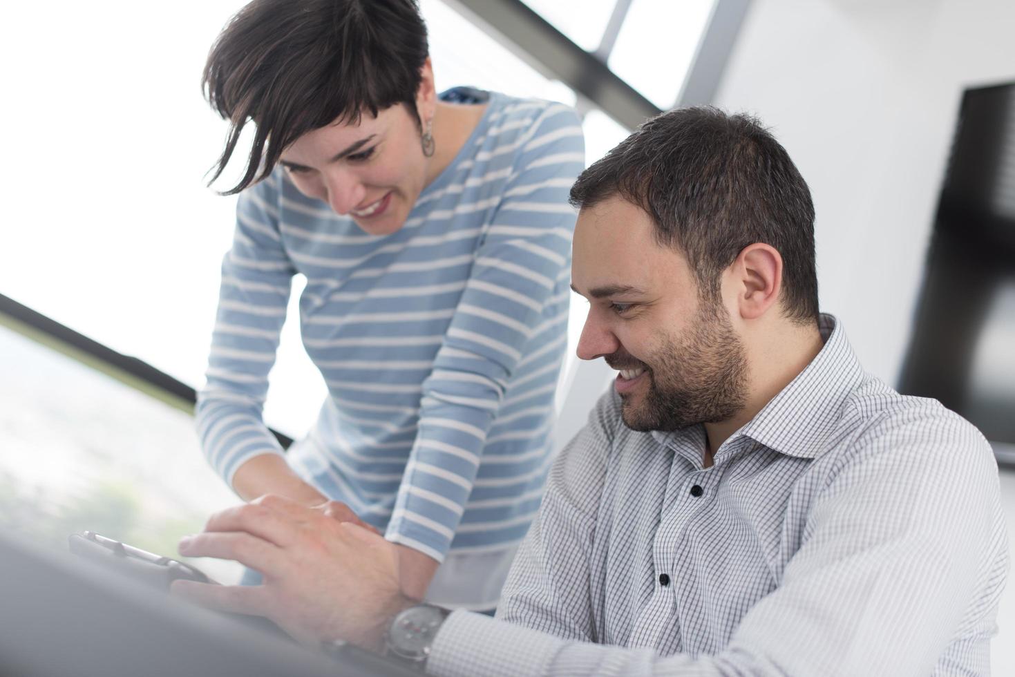 Zwei Geschäftsleute, die mit einem Tablet im Startup-Büro arbeiten foto