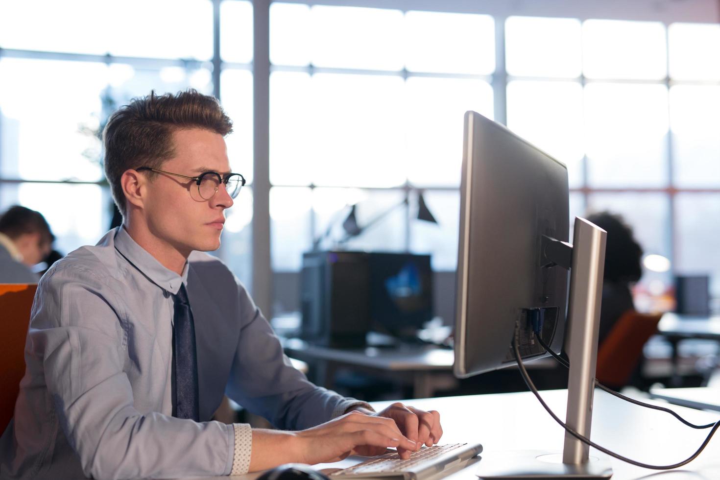 Geschäftsmann, der mit einem Computer im Startup-Büro arbeitet foto