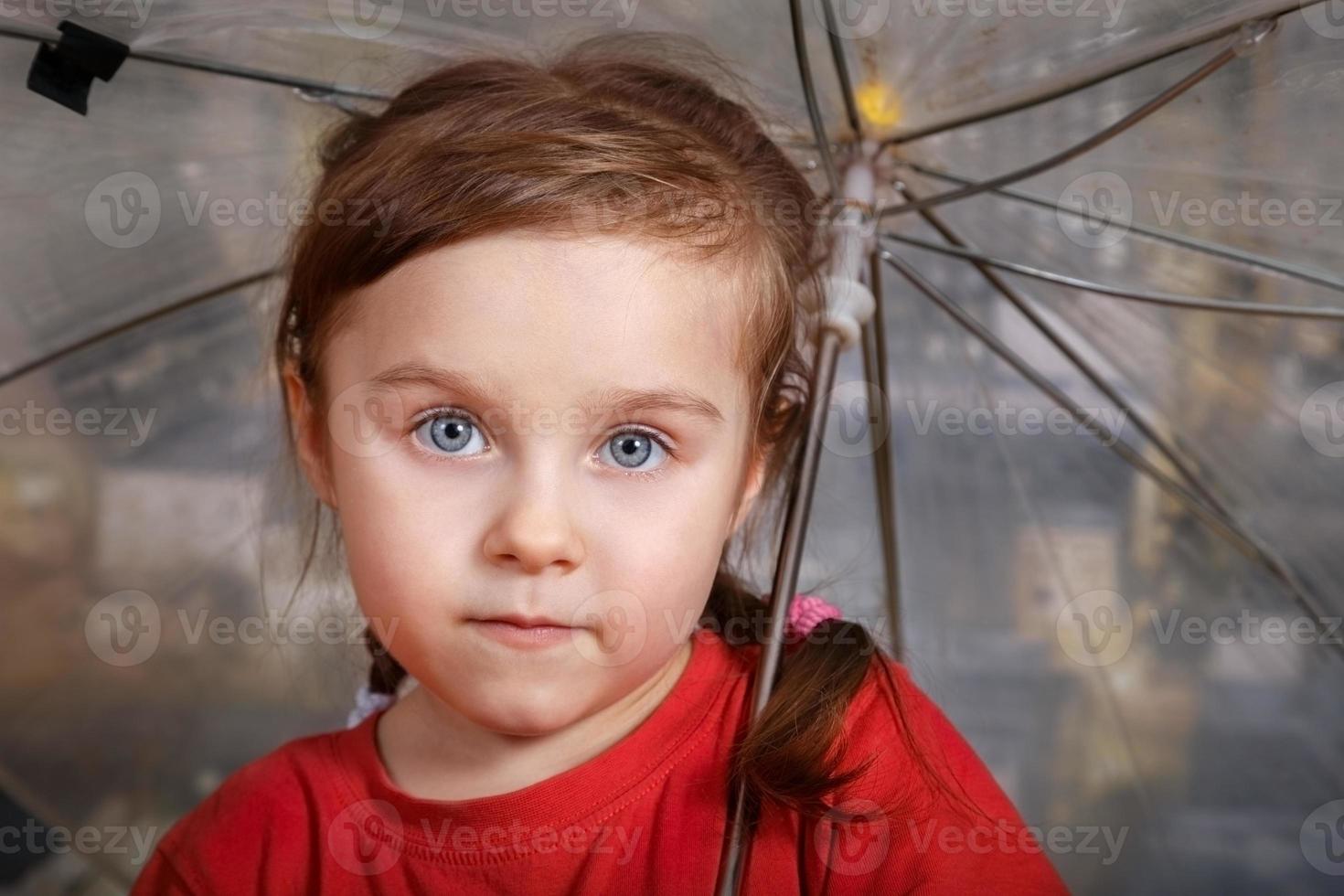 Porträt des kleinen süßen Mädchens mit einem Regenschirm foto