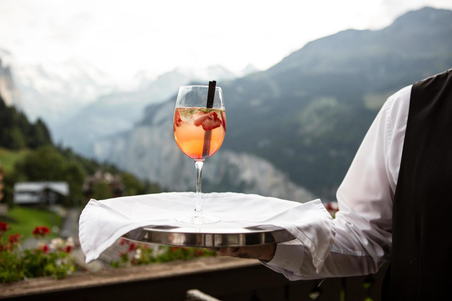 Server hält ein Tablett mit Getränk darauf foto