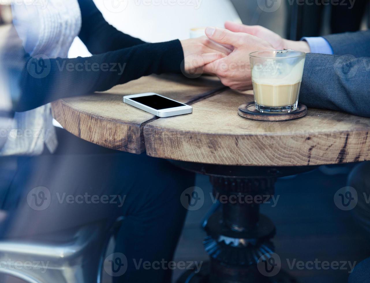 Mann hält die Hand seiner Freundin im Restaurant foto