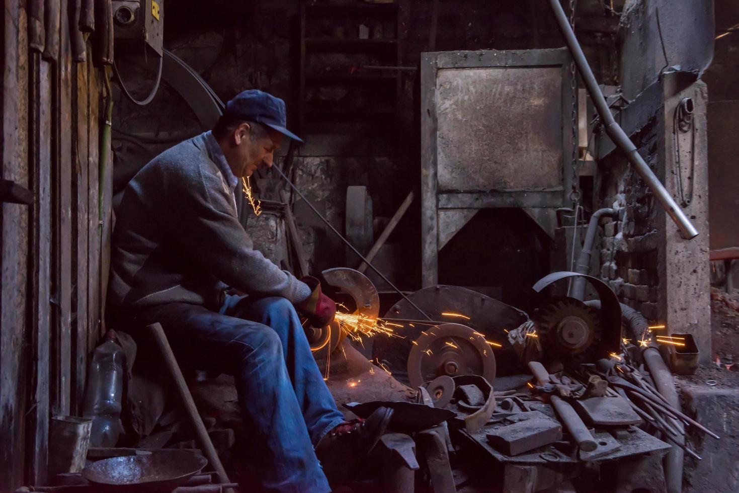 der Schmied, der Metallprodukte poliert foto