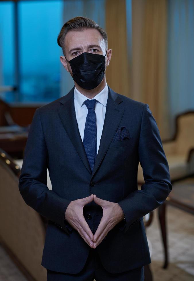 geschäftsmann, der im büro eine schützende gesichtsmaske trägt foto