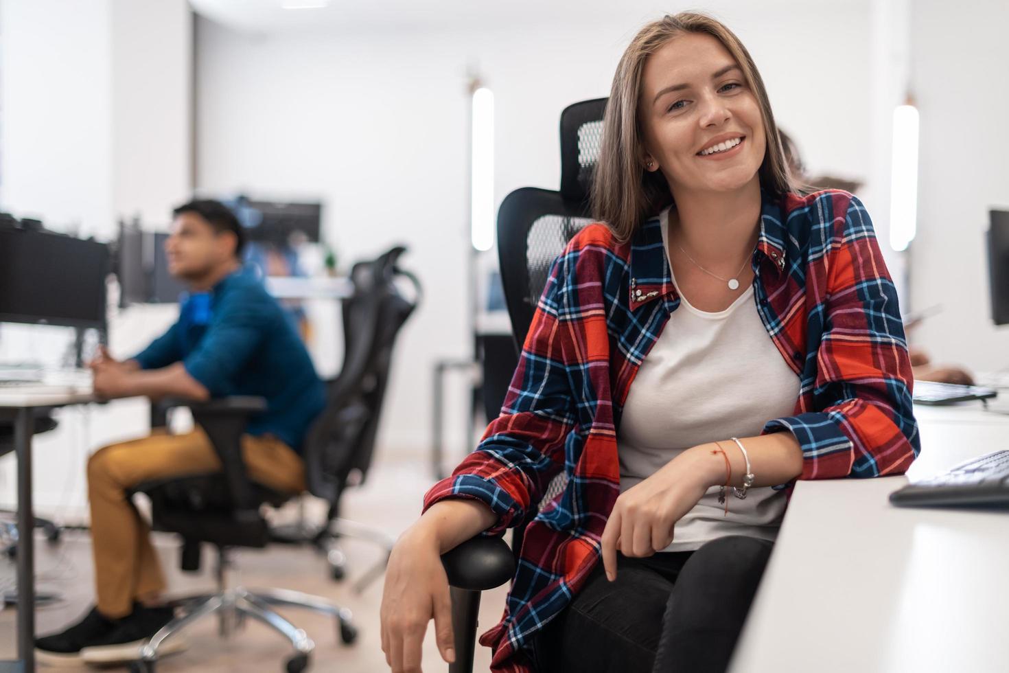 Lässige Geschäftsfrau, die an einem Desktop-Computer in einem modernen Großraum-Startup-Büro arbeitet. selektiver Fokus foto