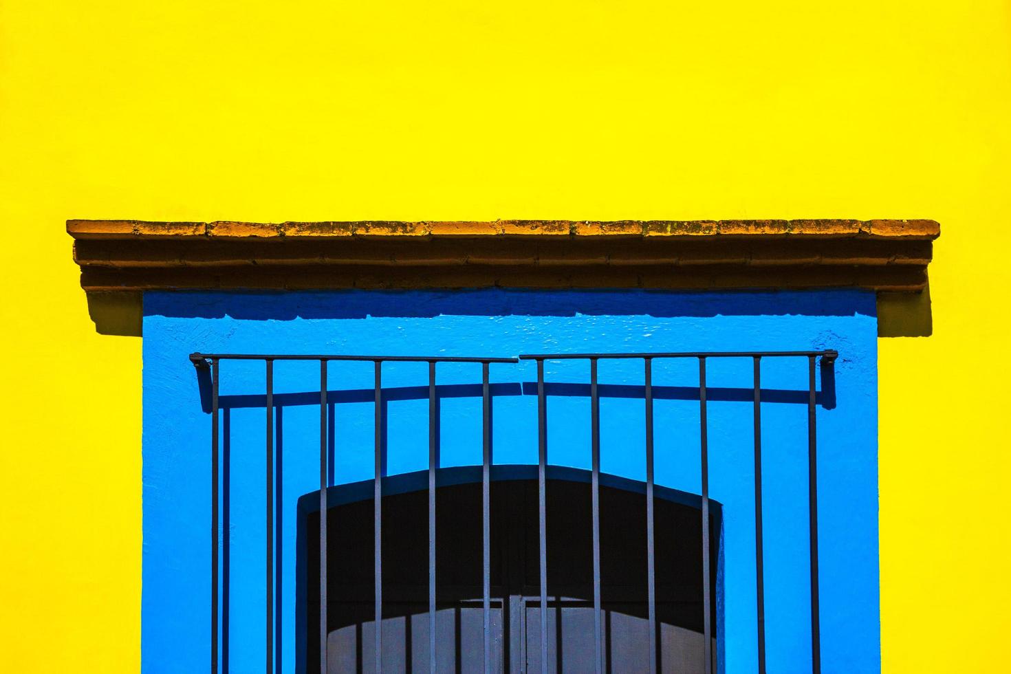 blaues Käfigfenster an gelber Wand foto