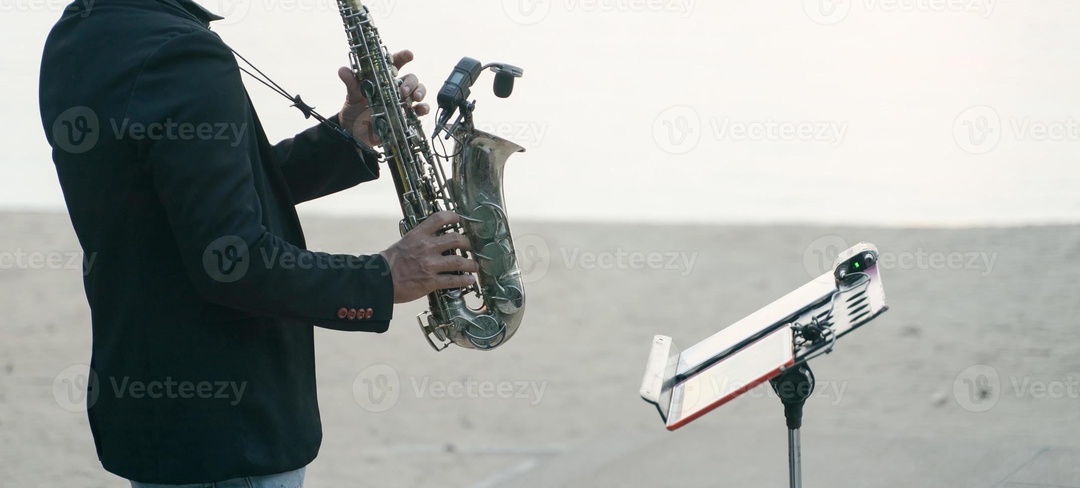 Musikermann, der Saxophon am Strand spielt. foto