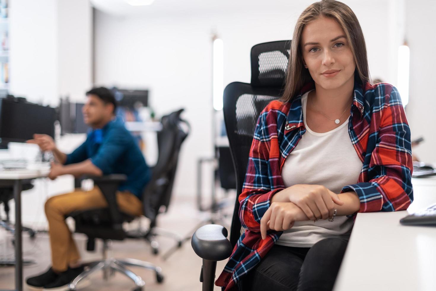 Lässige Geschäftsfrau, die an einem Desktop-Computer in einem modernen Großraum-Startup-Büro arbeitet. selektiver Fokus foto