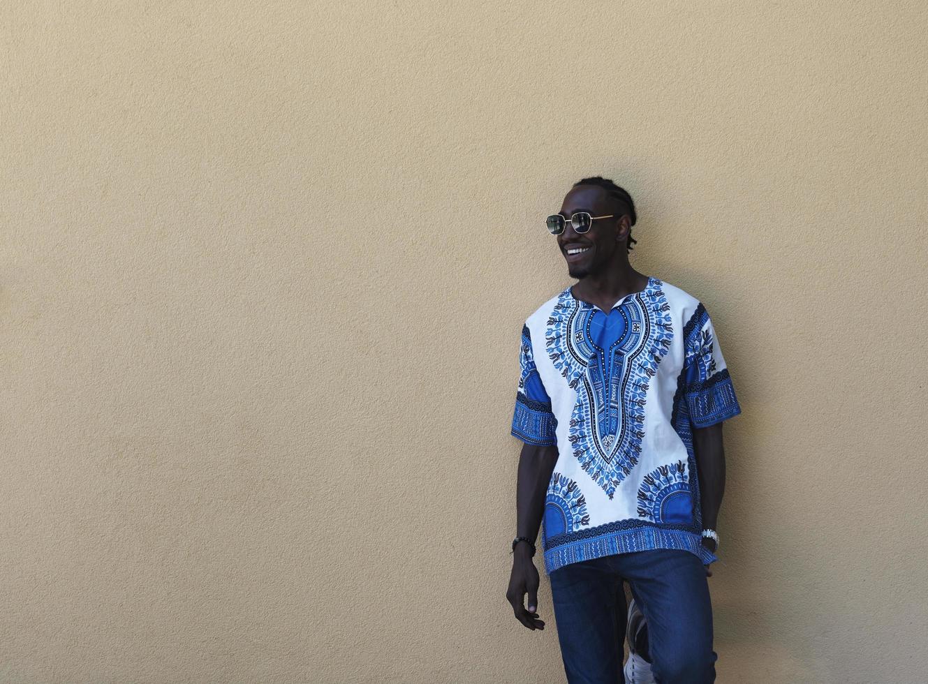 Porträt eines lächelnden jungen afrikanischen Mannes, der traditionelle Kleidung trägt foto