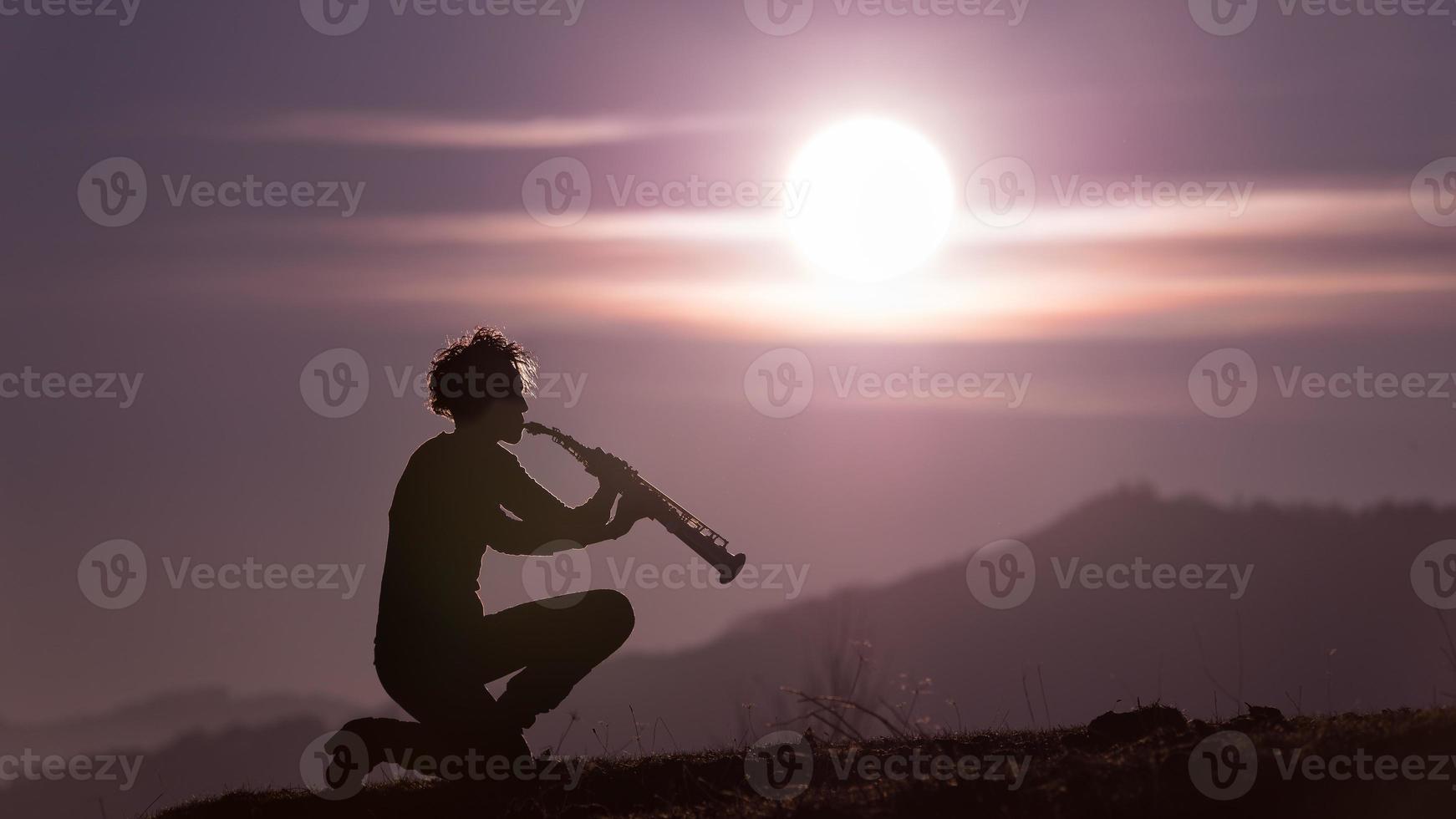 Saxophonspieler im lila Himmel bei Sonnenuntergang foto