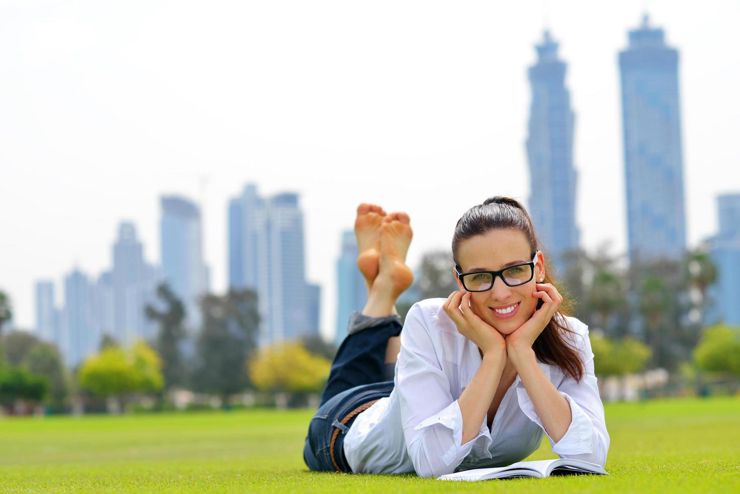 junge Frau, die ein Buch im Park liest foto