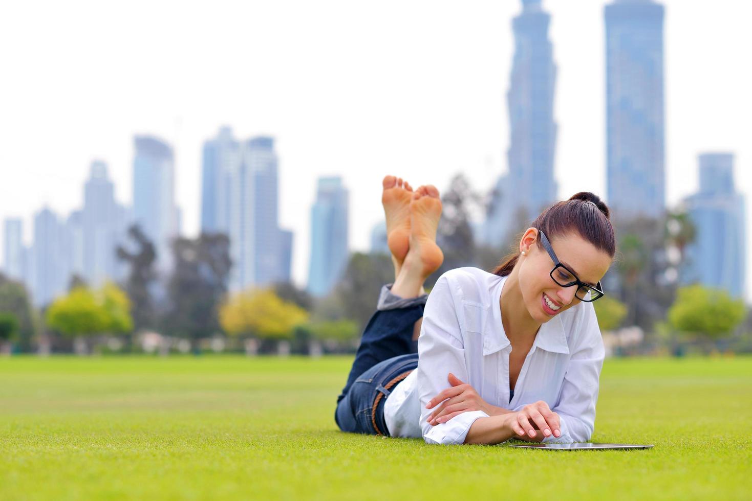 schöne junge Frau mit Tablet im Park foto