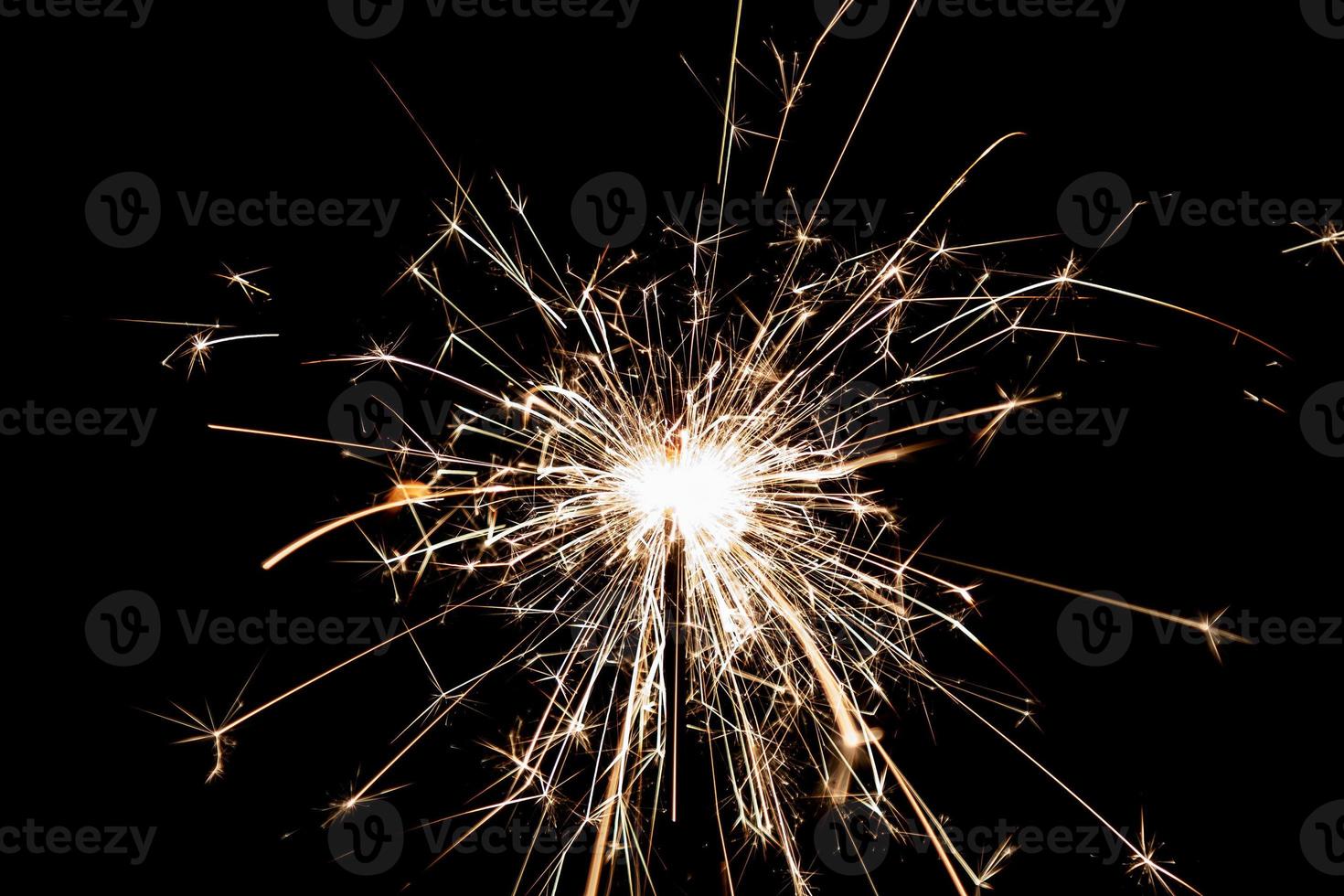 brennende Wunderkerze auf schwarzem Hintergrund isoliert. Thema Feuerwerk. Lichteffekt und Textur. foto