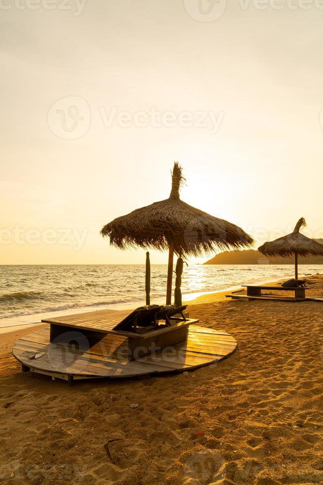 Strandkorb und Sonnenschirm mit Meeresstrand Hintergrund foto