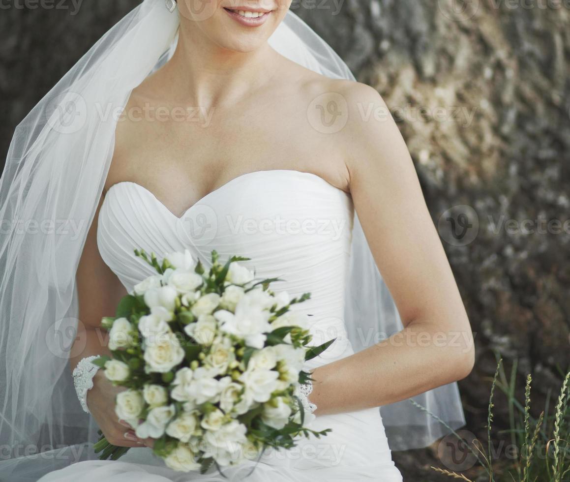 Porträt der schönen Braut mit Blumenstrauß in den Händen. foto
