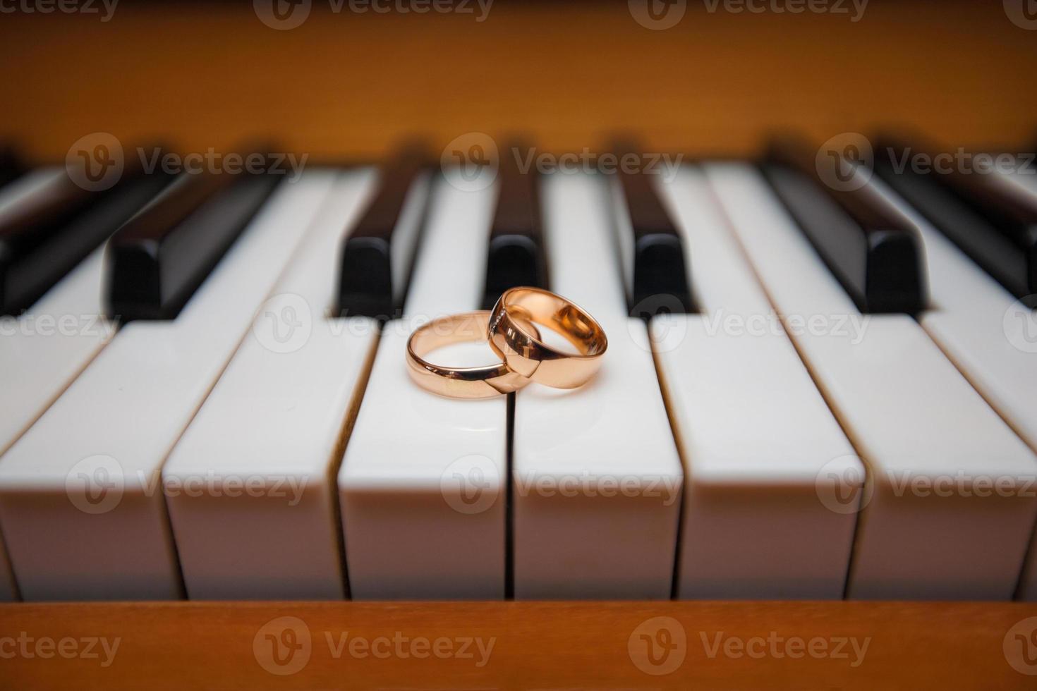 goldene Eheringe auf den Klaviertasten foto