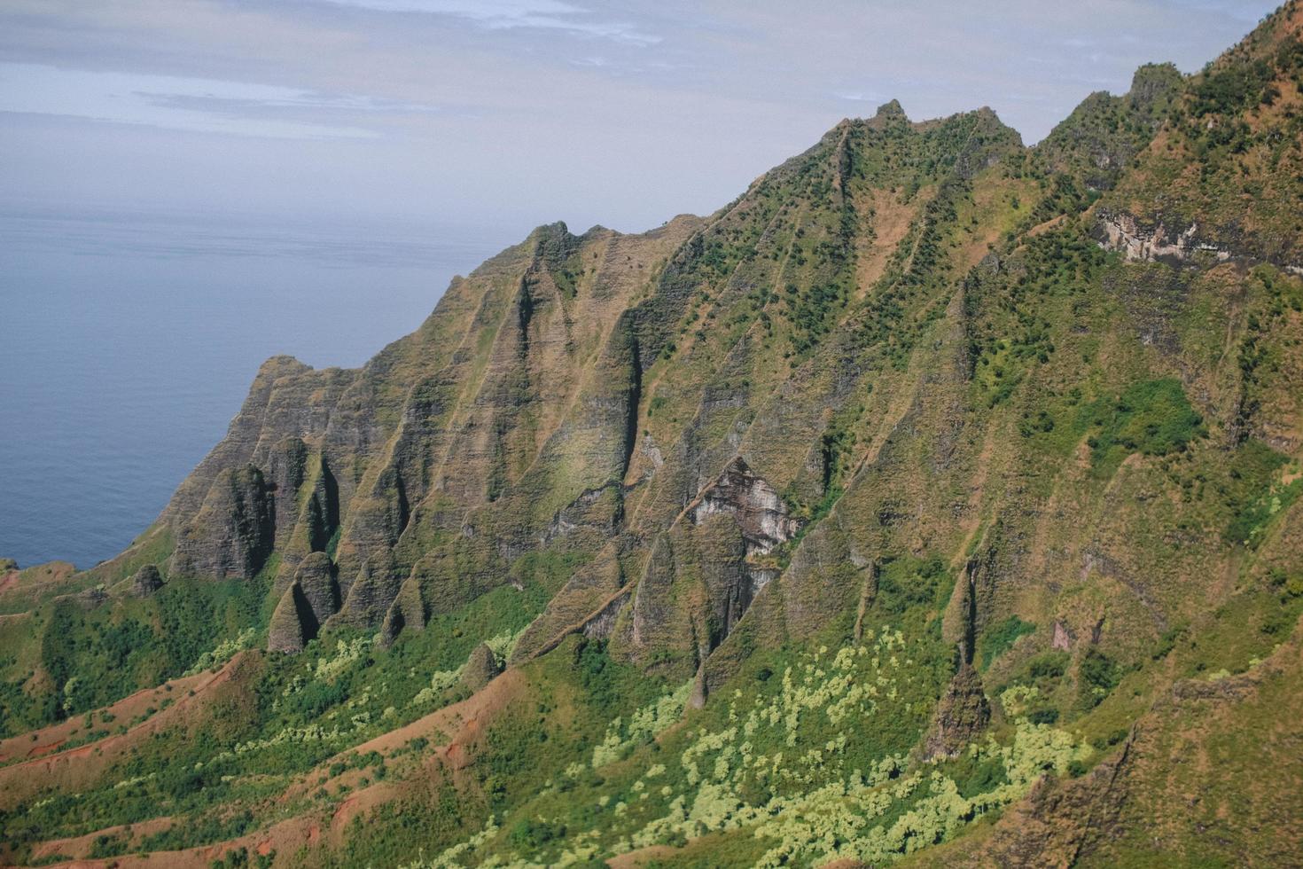 grüner Berg in der Nähe des Meeres foto