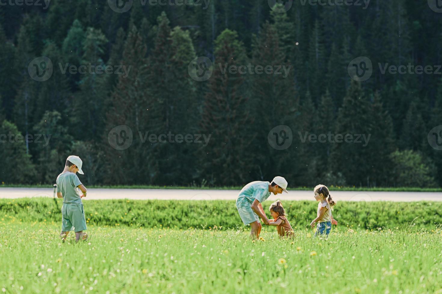 vier kinder spielen auf der alpenwiese in untertauern, österreich. foto