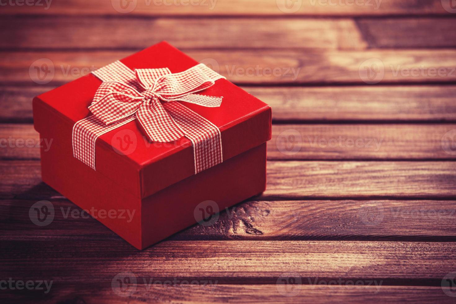 rote Geschenkbox auf Holztisch. foto