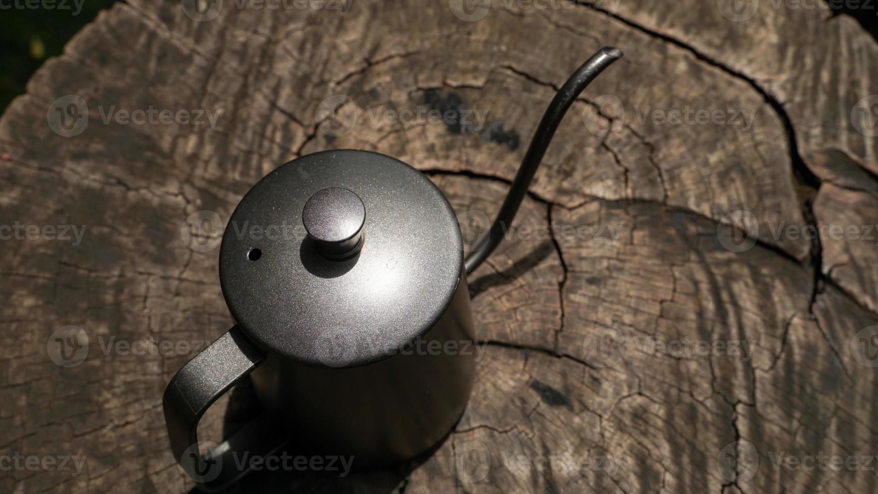 Das Filterkaffee-Set umfasst Kaffeebohnen, Filterkessel und eine Kaffeemühle. auf Holztisch legen. foto