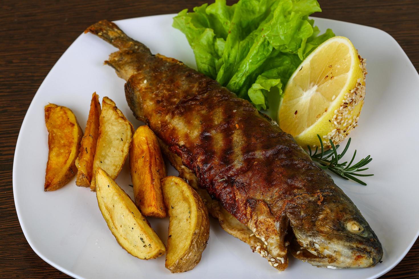 Gegrillte Forelle auf dem Teller und Holzhintergrund foto