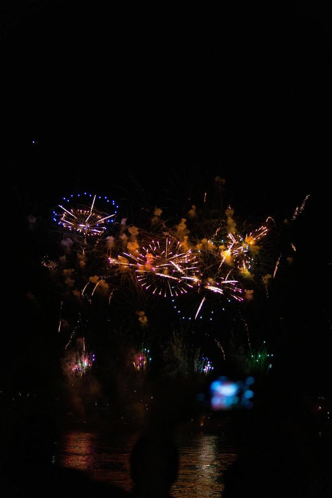 verschiedene Farben von Feuerwerkskörpern in der Nacht foto