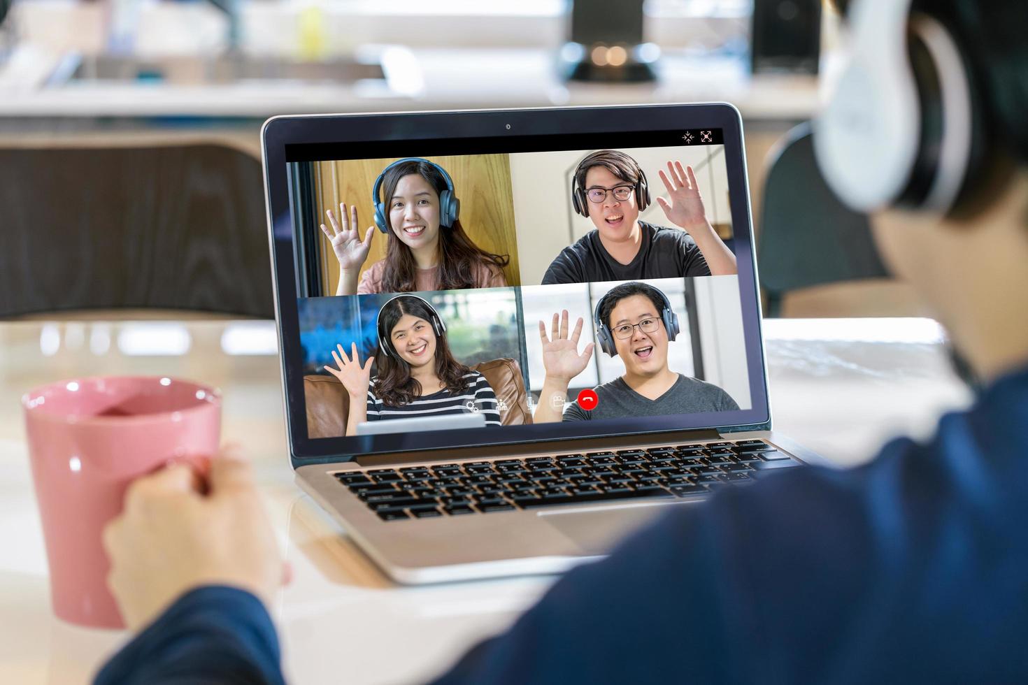 Rückansicht des asiatischen Geschäftsmannes auf Videoanruf mit Team foto