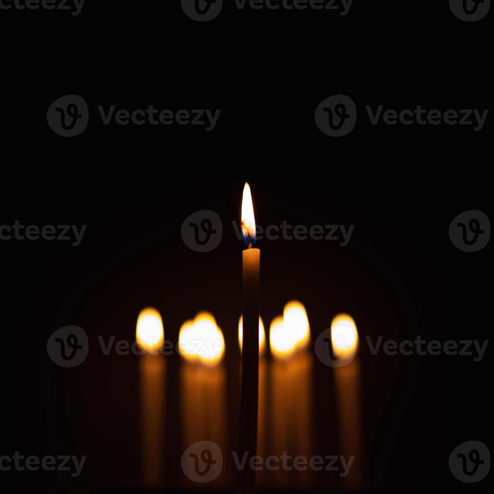 Kerzen wurden in der Dunkelheit angezündet, um einige Rituale wie orangefarbenes Licht durchzuführen. und konzentrieren Sie sich auf einige Kerzen, um sie hervorzuheben. Einige sind für Schärfentiefe und Bokeh unscharf. foto