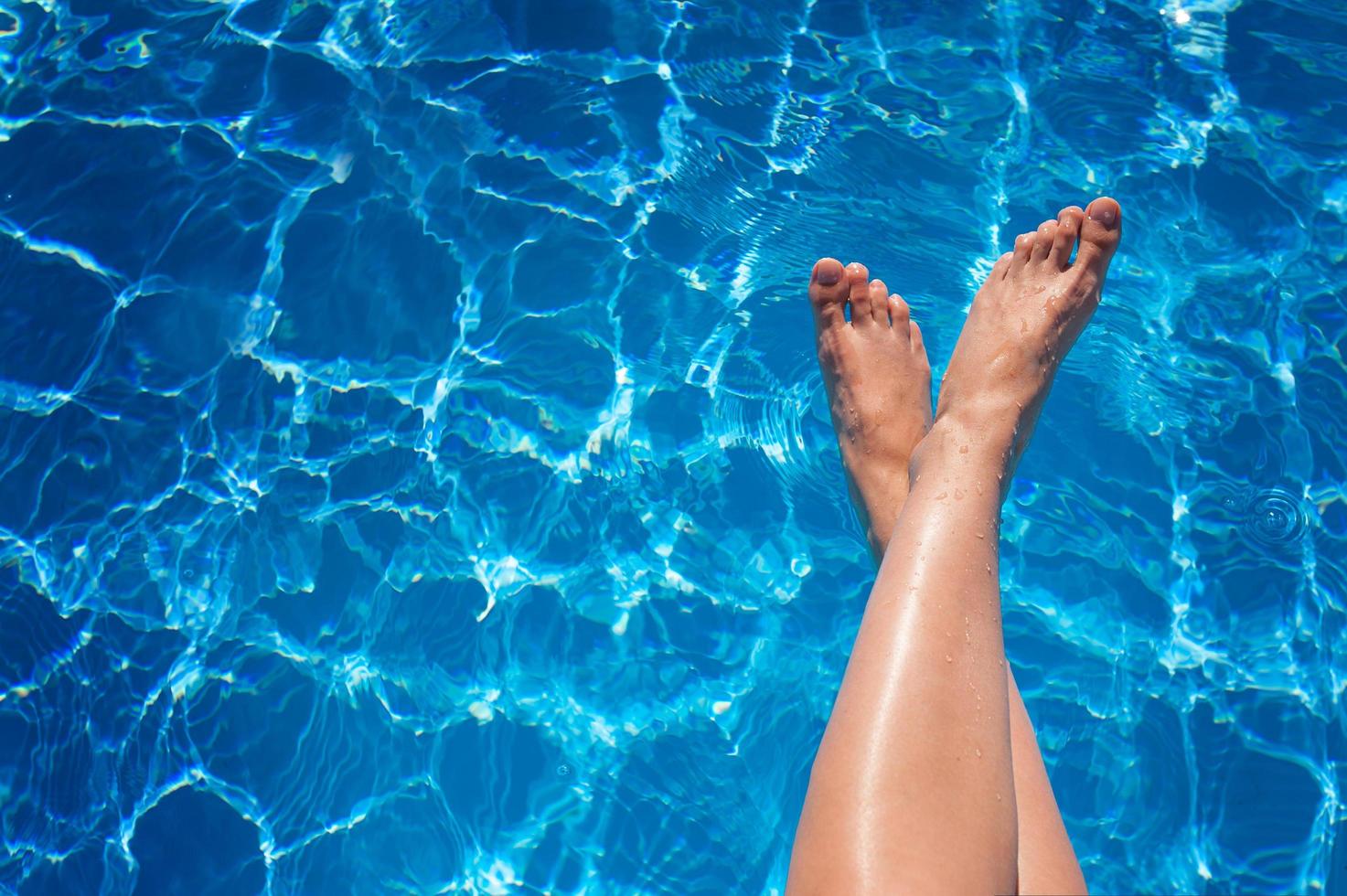 Frauenbeine im Pool foto