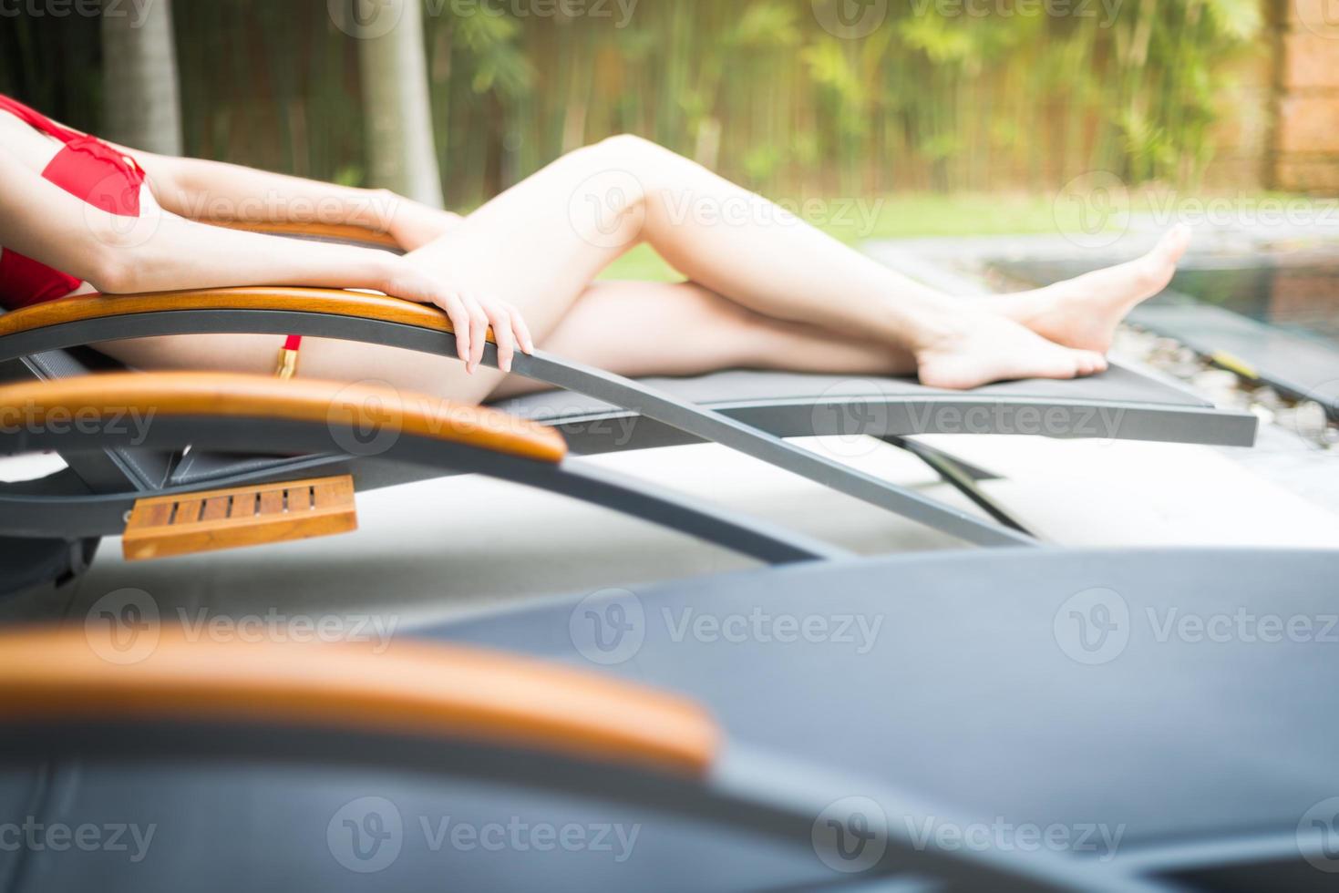 elegantes Mädchen im Badeanzug, der auf Sonnenliege liegt. foto