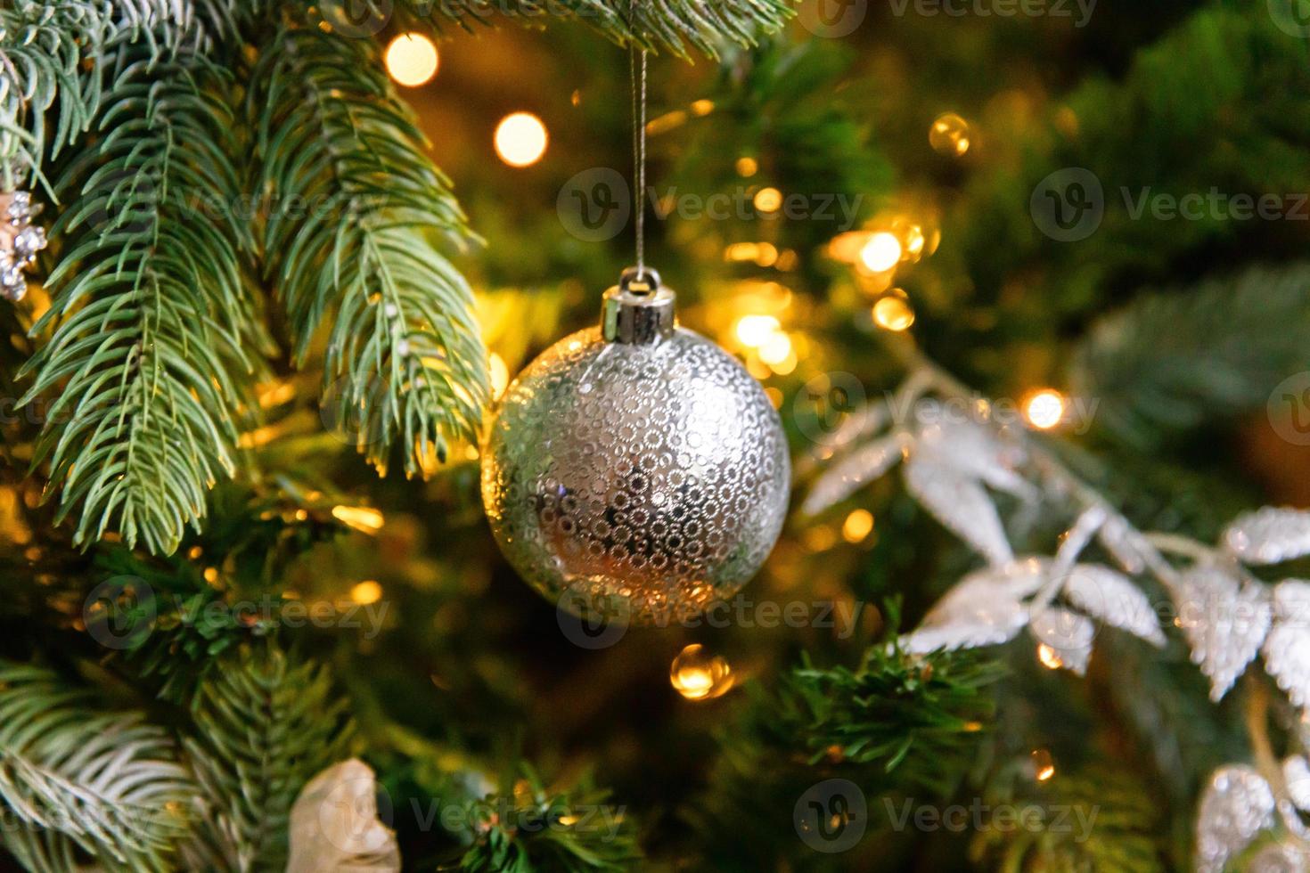 klassischer weihnachtlich geschmückter neujahrsbaum. weihnachtsbaum mit weißen und silbernen dekorationen, ornamenten spielzeug und ball. moderne Innenarchitekturwohnung im klassischen Stil. Heiligabend zu Hause. foto