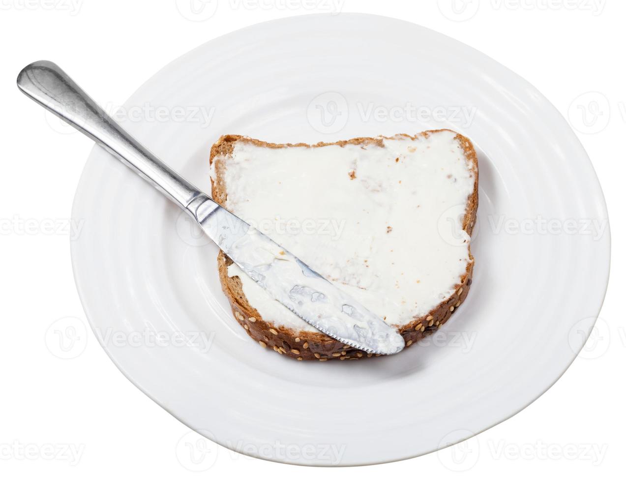 Brot und Weichkäse-Sandwich mit Messer auf dem Teller foto