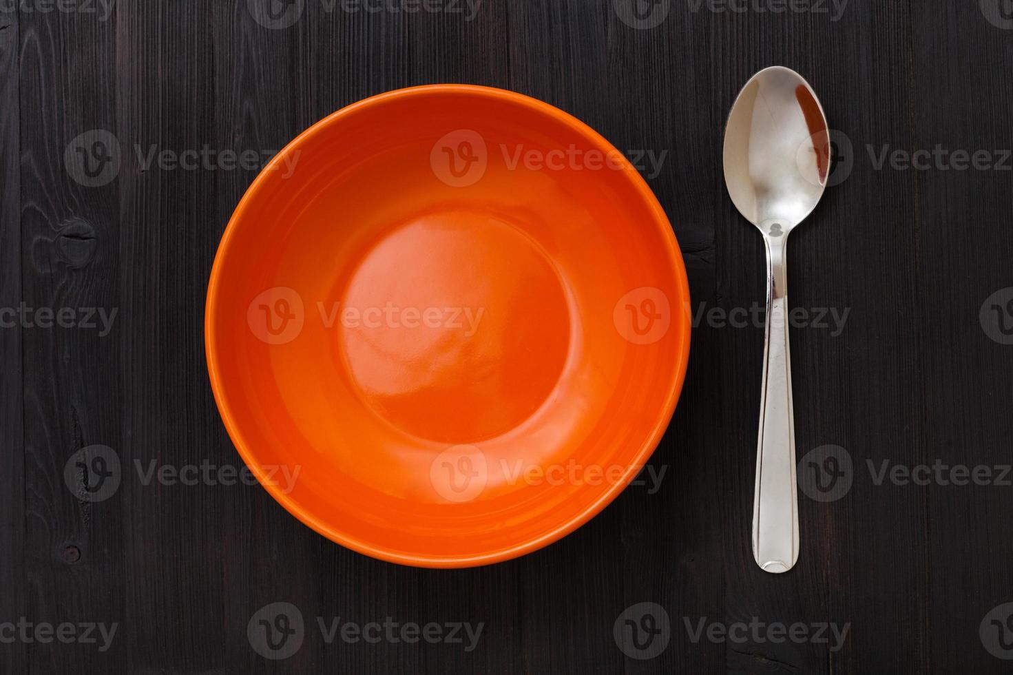 Orangenschale und Löffel auf dunkelbraunem Tisch foto