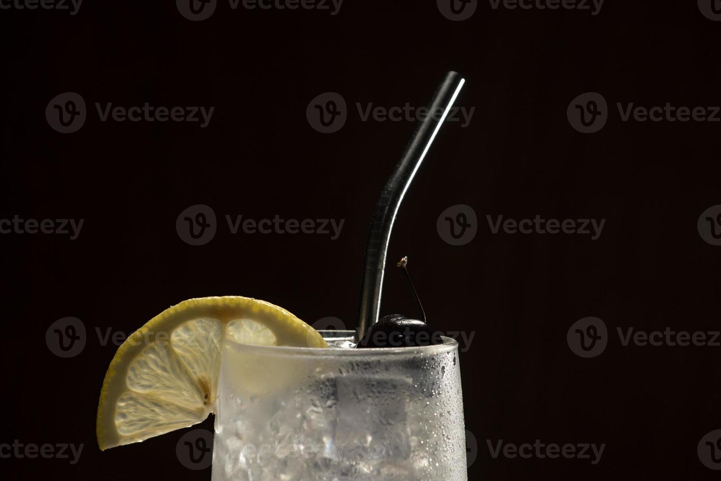 tom collins cocktail auf schwarzem hintergrund, umweltfreundlicher metallstrohhalm foto