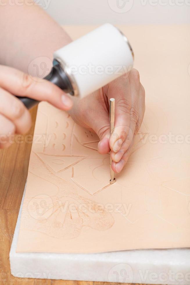 Handwerker setzt Ornament durch Stanzwerkzeug foto