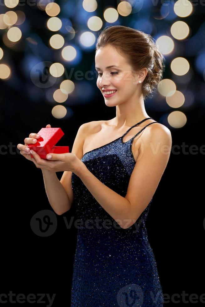 lächelnde Frau, die rote Geschenkbox hält foto