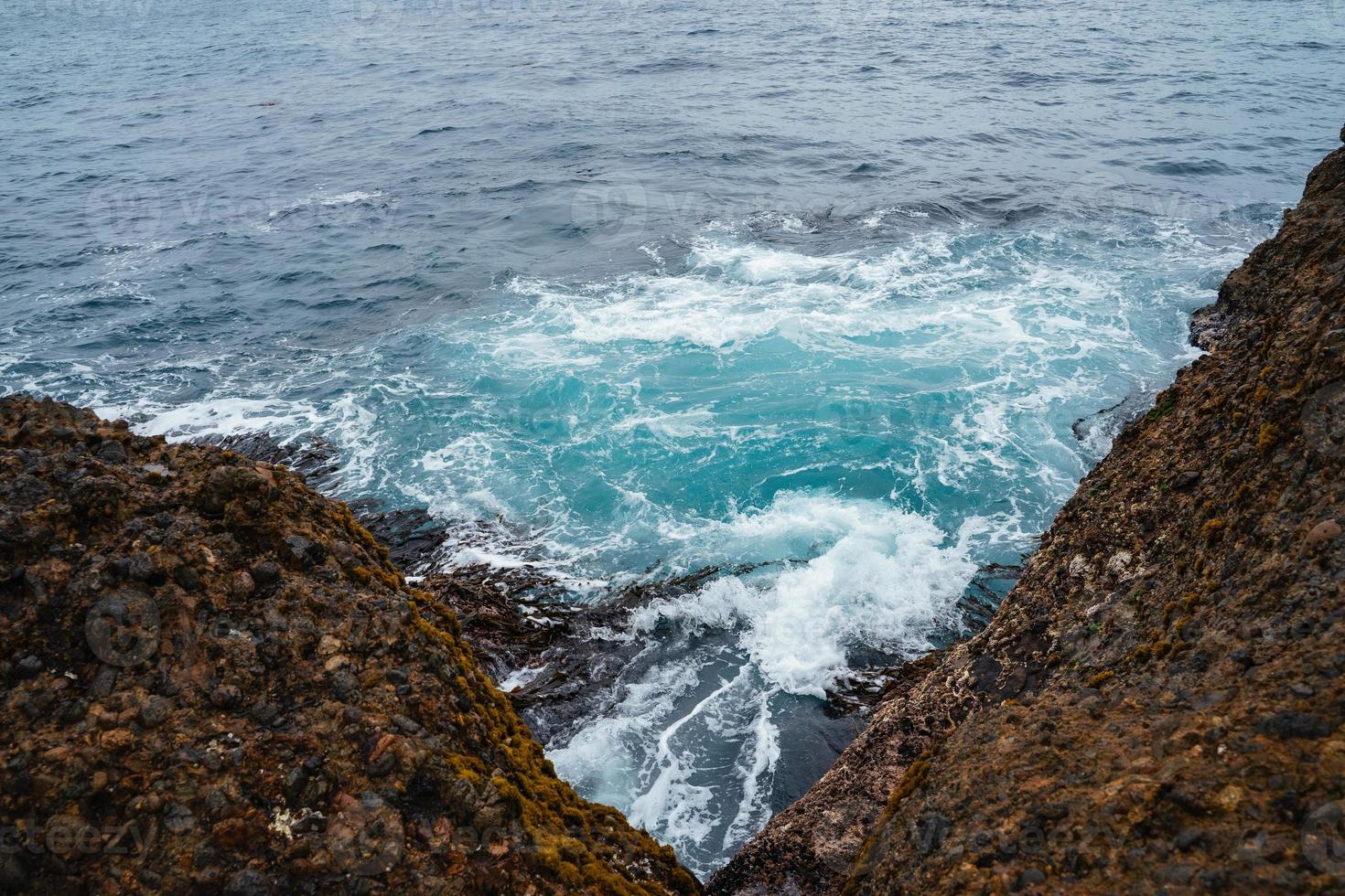 Meereswelle über Felsen und Algen foto