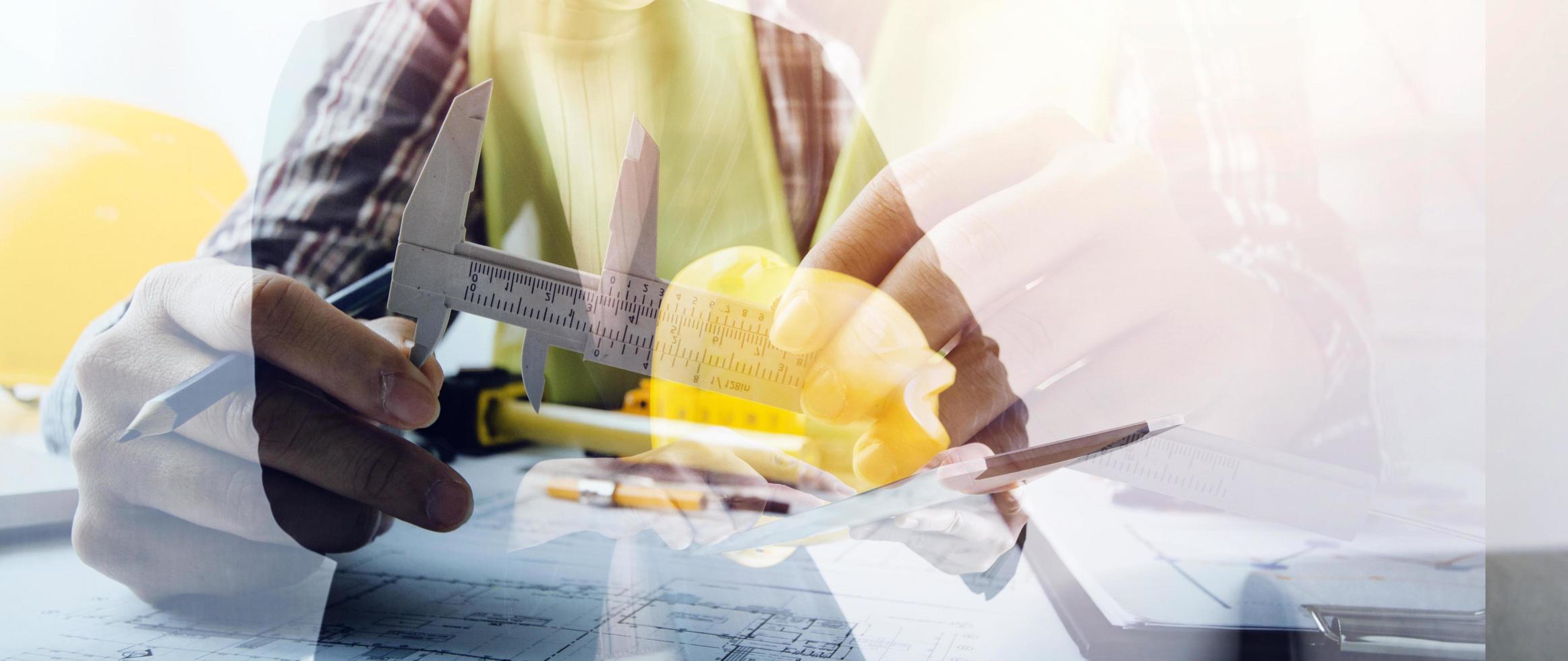 Bauingenieur, der an der Blaupause arbeitet, um große Geschäftsgebäude im Büro zu bauen. Engineering-Tools und Konstruktionskonzept. foto