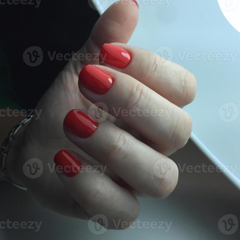 Nahaufnahmefoto einer schönen weiblichen Hand mit rotem Nagel foto