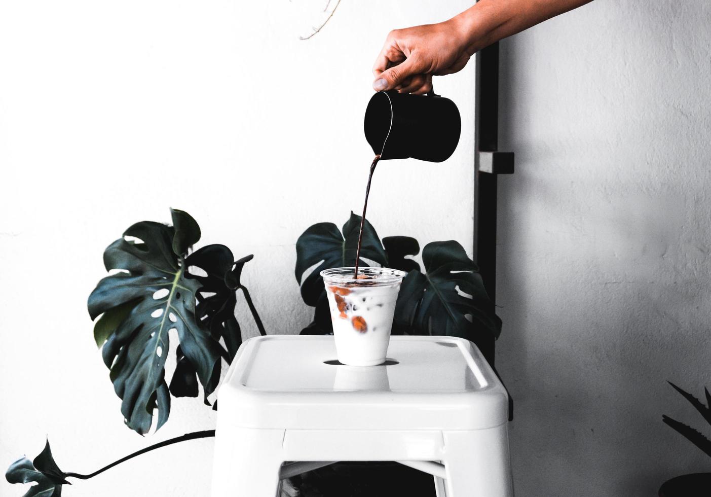 Person, die Kaffee in Tasse gießt foto